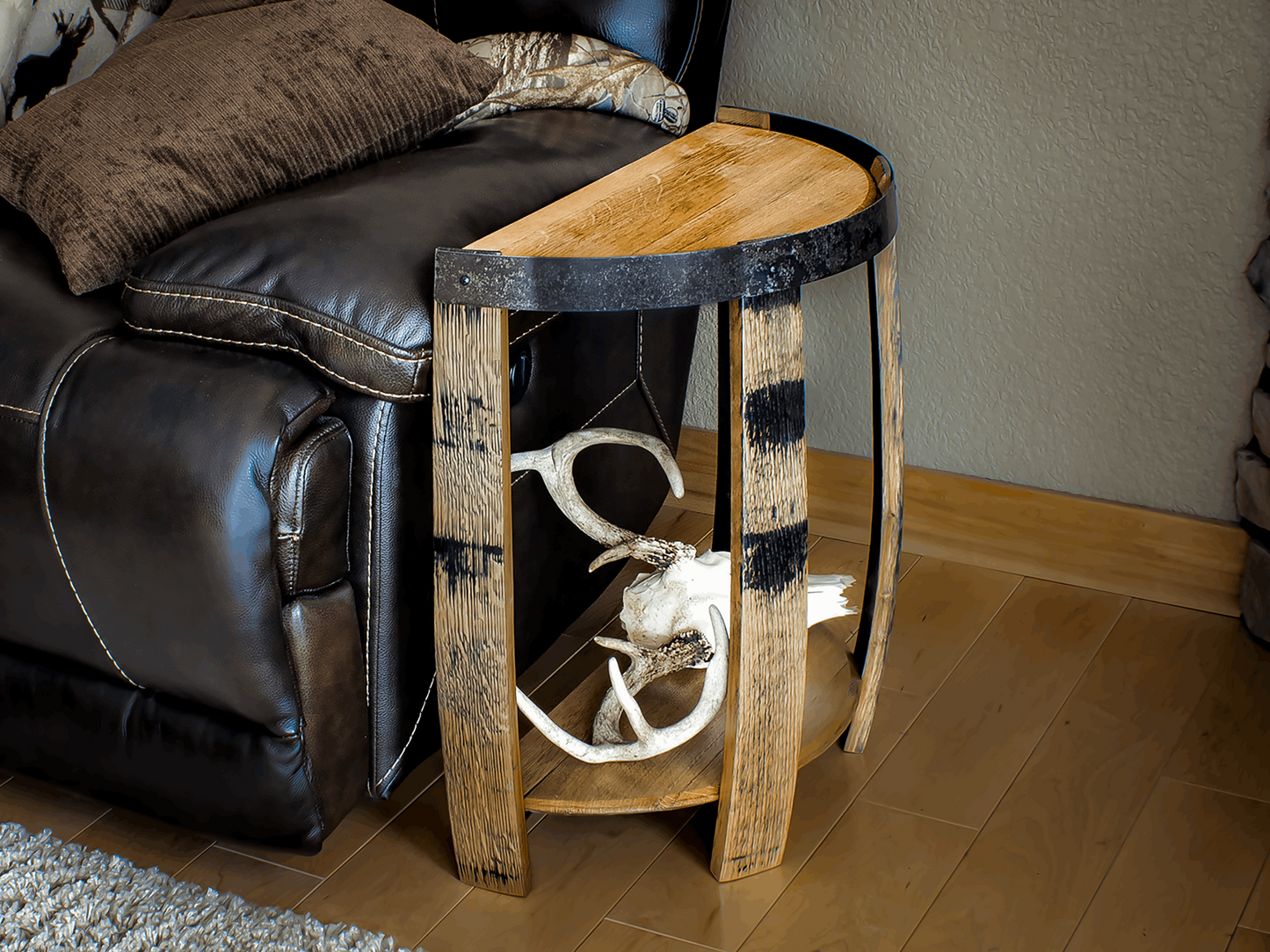 Rustic half whiskey barrel end table made from authentic reclaimed barrel parts, featuring unique wood grain and metal banding, perfect for a cozy living room or den.