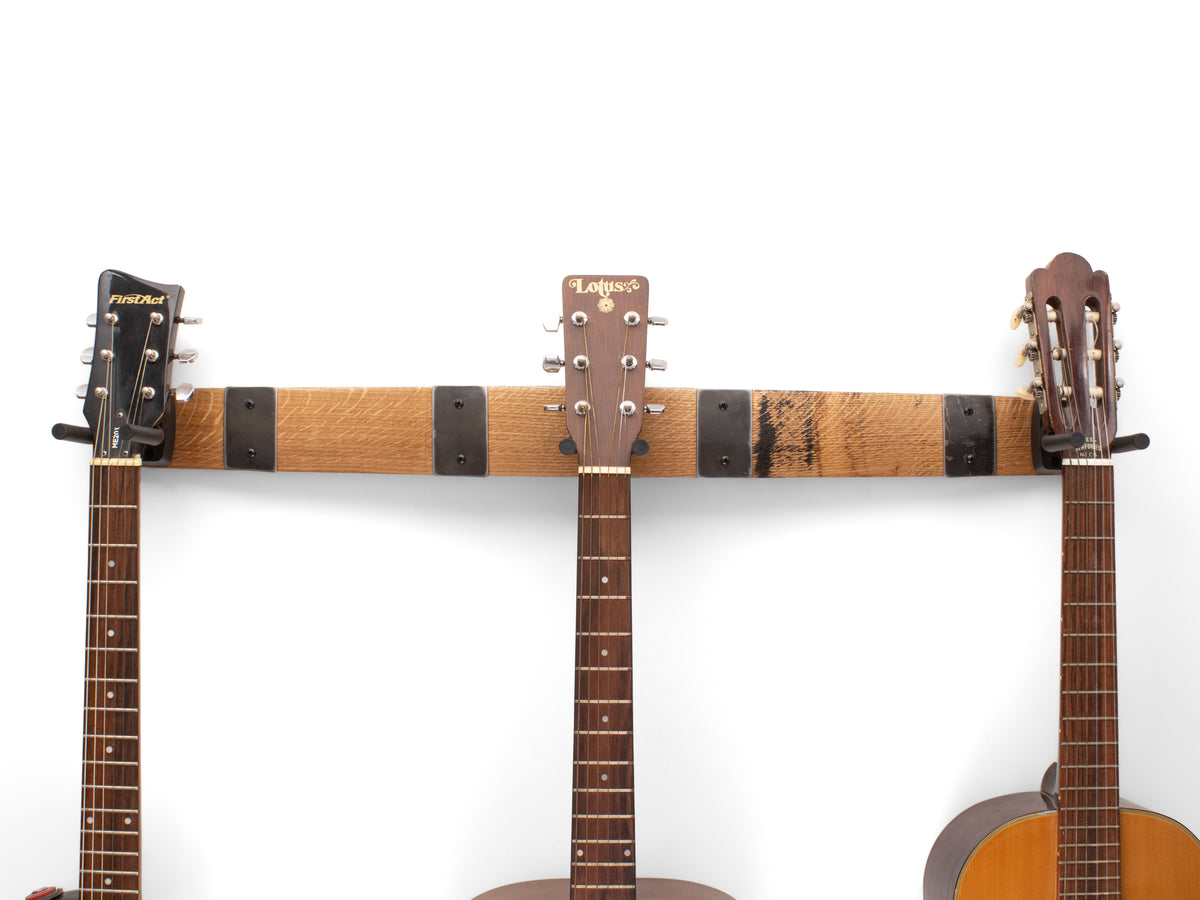 Natural finish 36-inch whiskey barrel stave triple guitar hanger with four barrel hoop accents holding three guitars