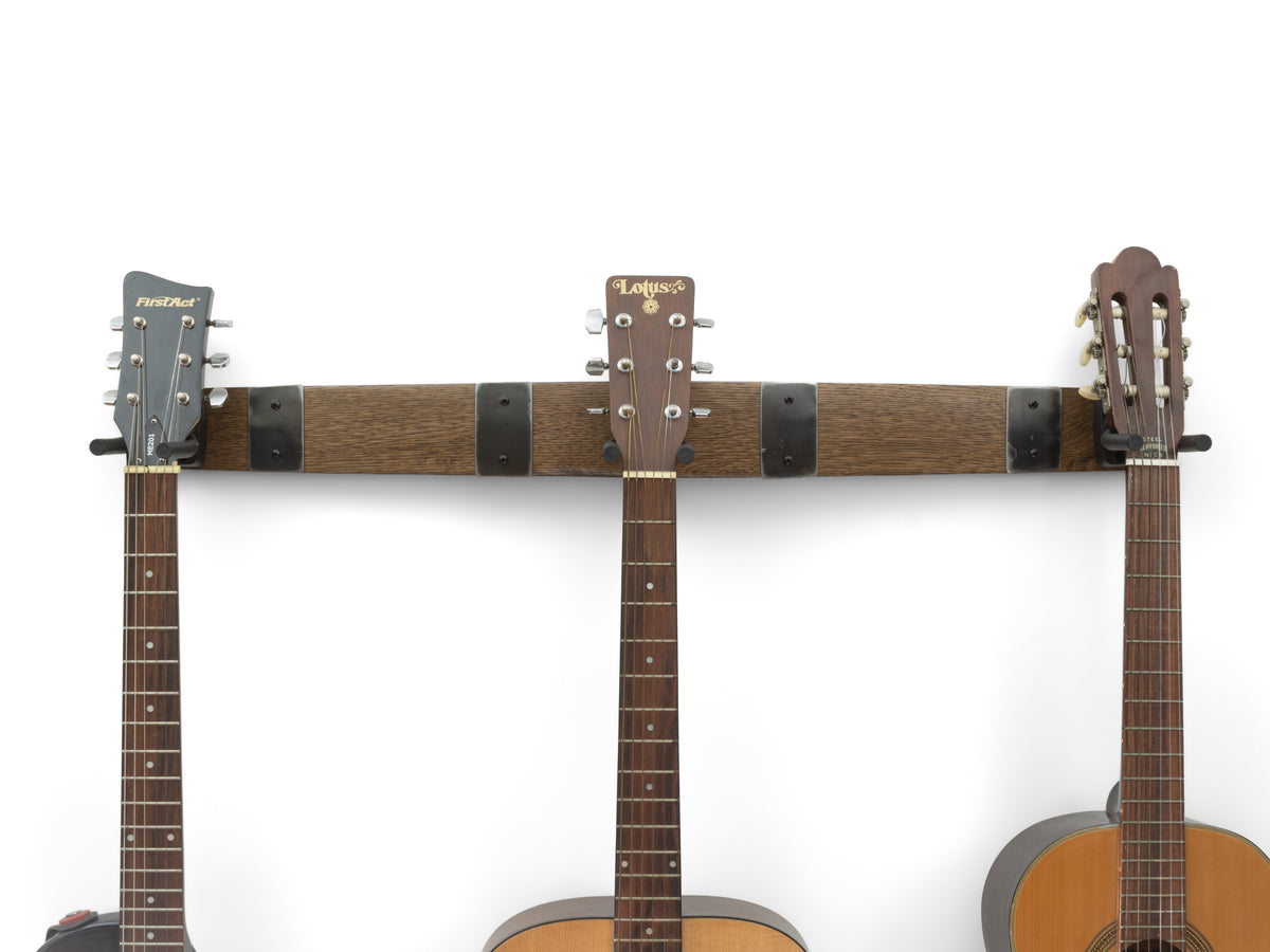 True Brown finish 36-inch whiskey barrel stave triple guitar hanger with four barrel hoop accents holding three guitars